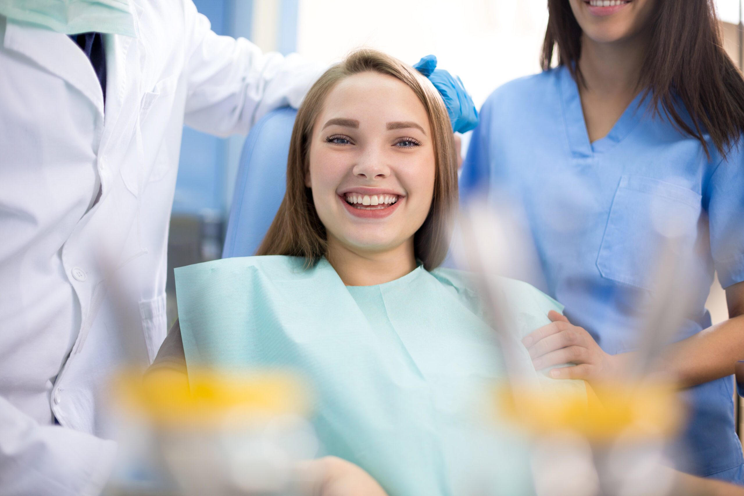 Happy girl in dental chair after treatment when pain stopped in clinic