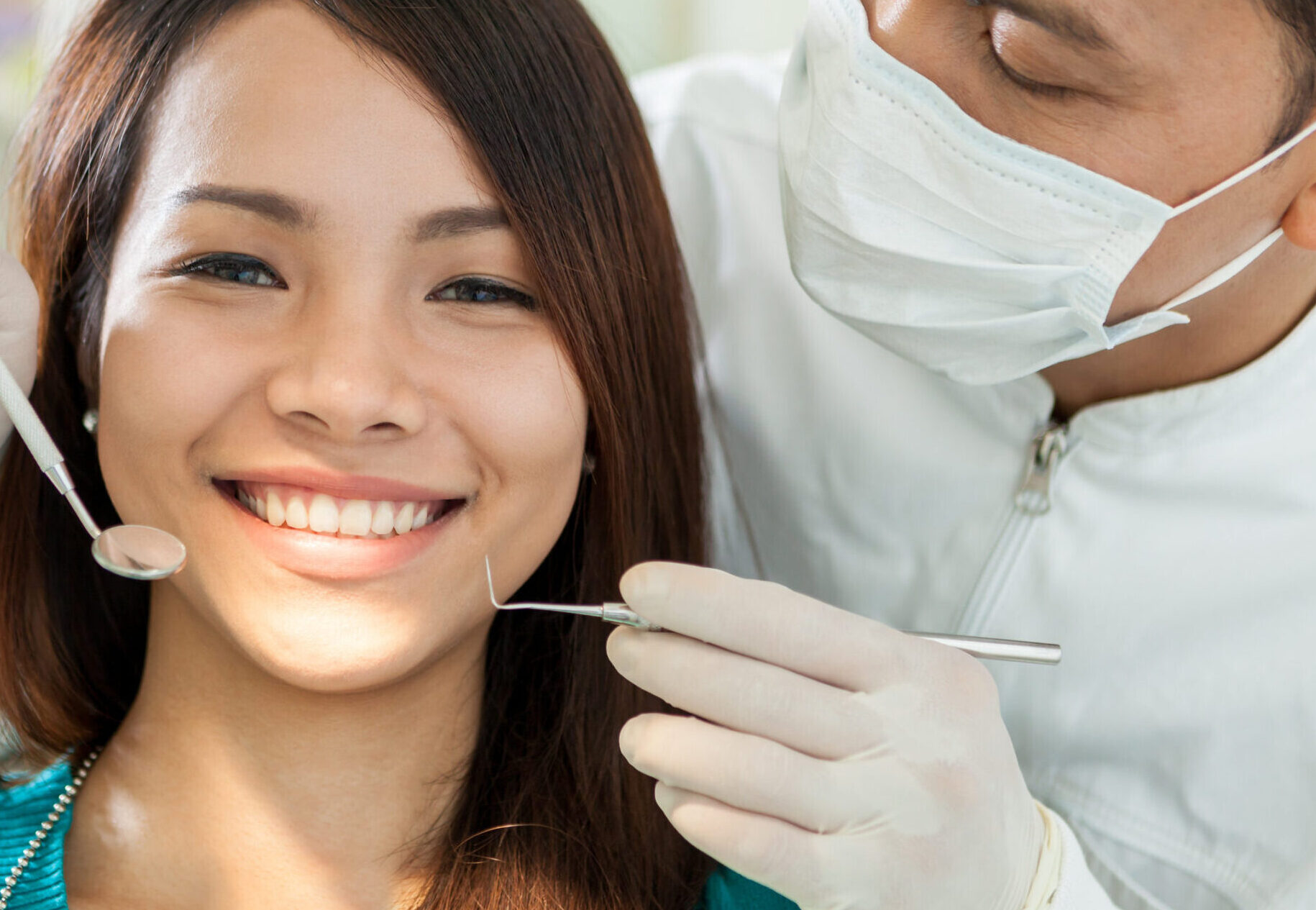 Portrait of smiling asian woman sitting at the dentist